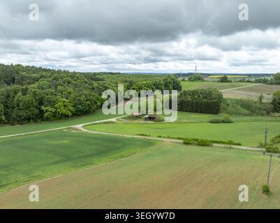Aerial view of rural fields and small farm buildings surrounded by lush ...