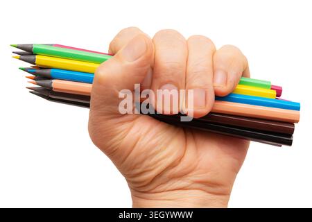 A hand grips multiple colored pencils showing different colors for drawing. The hand shows strength and focus with creativity in mind. Stock Photo