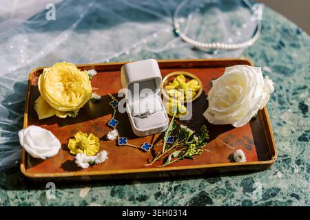 Elegant Engagement Ring with Flowers and Jewelry on Decorative Tray Stock Photo
