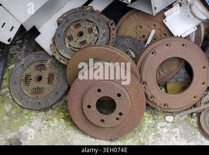 Rusty automotive components, including brake discs, clutch plates, and flywheels, forming a corroded metal pile representing waste, recycling, and obs Stock Photo
