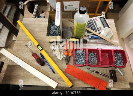 Assorted construction tools and fasteners on a wooden workbench, creating a scene of home renovation, carpentry, and do it yourself repair work for va Stock Photo