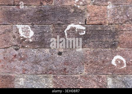 Close up of red sandstone masonry wall showing weathered blocks, mortar and natural stone texture, useful as an architectural or background surface Stock Photo