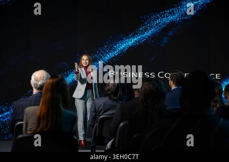 Professional businesswoman delivering inspirational business speech, highlighting networking for development. Female speaker engages audience at event in auditorium conference hall. Stock Photo