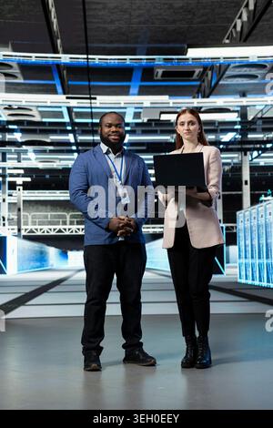 Working together, server racks and smiling engineering team in data center installing and upgrading systems. Monitoring automation, IT infrastructure and happy teamworking colleagues in server room Stock Photo