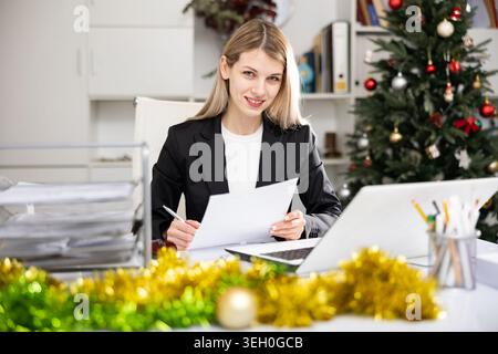 Woman working with documents during Christmas Stock Photo