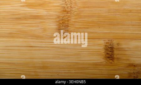 Golden bamboo wood grain texture with fine linear pattern, natural surface details and warm tones for design backgrounds. Stock Photo