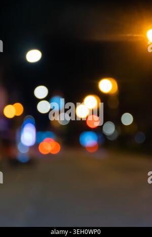 Blurred urban lights at night creating colorful bokeh effect with abstract city atmosphere and illuminated street background Stock Photo