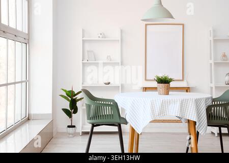 Table with chairs and blank poster in interior of dining room Stock Photo