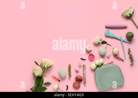 Frame made of white rose flowers and makeup products on pink background Stock Photo