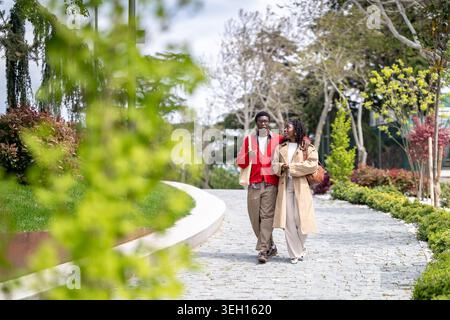Relaxed african american man and woman on date in city enjoying conversation and warm spring day. Stock Photo