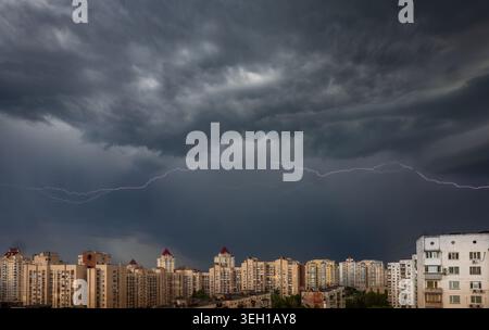 Thunderstorm over Obolon district in Kyiv, Ukraine with dramatic lightning strike above urban skyline at night during summer storm and extreme weather Stock Photo