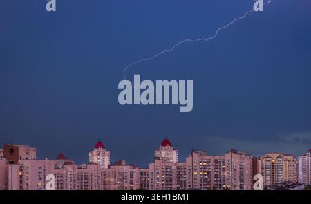 Thunderstorm over Obolon district in Kyiv, Ukraine with dramatic lightning strike above urban skyline at night during summer storm and extreme weather Stock Photo