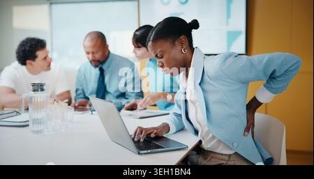 Woman, back pain and laptop in meeting at office with typing, injury and bad posture at finance company. Person, muscle strain and ache with spine Stock Photo