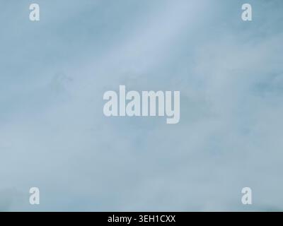 Minimal cloudy sky background featuring soft blue tones and subtle overcast texture. Clean atmospheric backdrop ideal for weather concepts, design tem Stock Photo