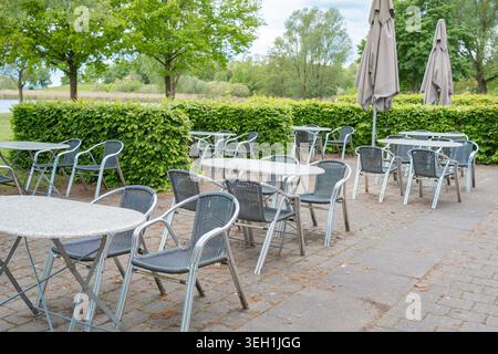 Empty restaurant patio waiting for customers on a bright day. Concept of hospitality business, outdoor dining, catering, resort leisure, and tourism. Stock Photo