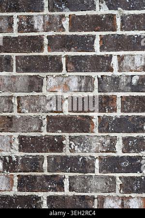 Close up of a brown brick wall surface with heavy uneven white mortar joints Stock Photo