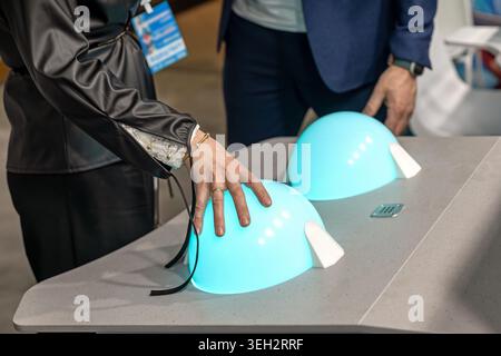 Visitor Touching Interactive Light Exhibit Display. Close-up of a visitor touching a glowing blue interactive display at a technology exhibition or Stock Photo