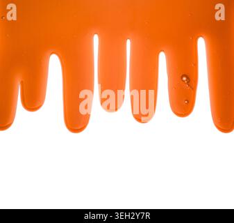 Orange liquid transparent gel dripping down against white background. Stock Photo