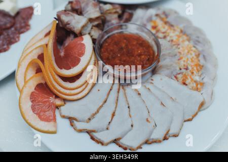 Delicate sliced meat arranged on a white plate Stock Photo