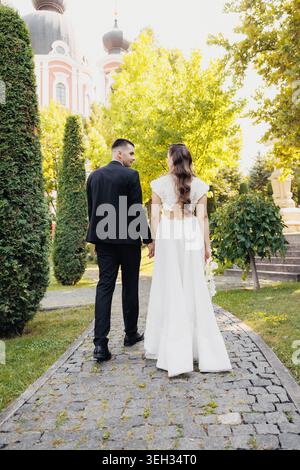 Couple walks hand in hand down stone path Stock Photo