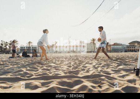 Sunlit beach, two players in motion Stock Photo