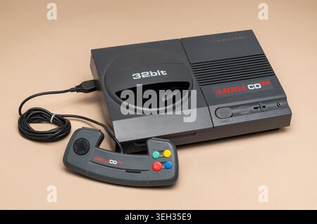 Pavia, Lombardy, Italy-March 30, 2026: Commodore Amiga CD32 32-bit CD-ROM game console from 1993 with original gamepad controller. Rare retro gaming c Stock Photo