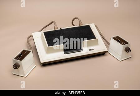 Pavia, Lombardy, Italy-March 30, 2026: Magnavox Odyssey, the world's first home video game console from 1972, with two original controllers. White des Stock Photo