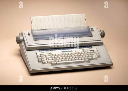 Pavia, Lombardy, Italy-March 30, 2026: Olivetti ET Compact 70 electronic typewriter from the 1980s. Grey design with full keyboard and paper loaded, o Stock Photo