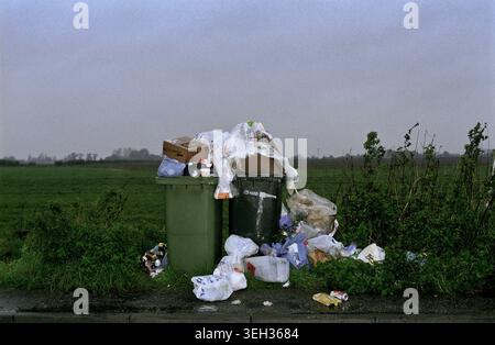Overflowing rubbish bins in the countryside, uncollected by the council. Stock Photo