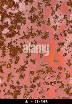 Vertical close up rusty metal surface with corrosion, peeling texture and distressed red painted background, suitable for abstract industrialbackdrop Stock Photo