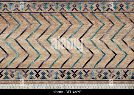 Geometric brickwork with turquoise and blue glazed tiles on the wall of Bibi Khanum Mosque in Samarkand. Ideal for travel publications, heritage docum Stock Photo