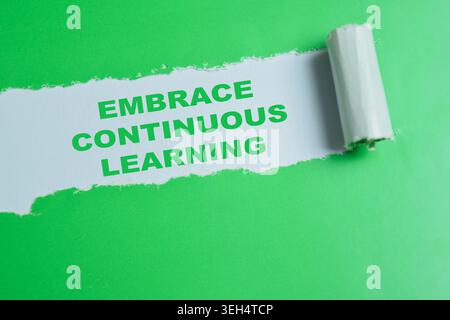 Embrace continuous learning text written in torn paper. Stock Photo