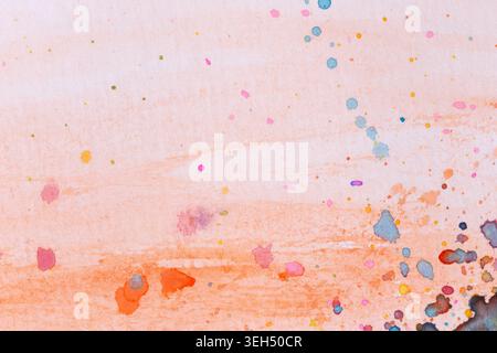 Macro close-up of colorful watercolor splashes, splatters & stains on orange background. Abstract high resolution full frame textured paper background Stock Photo