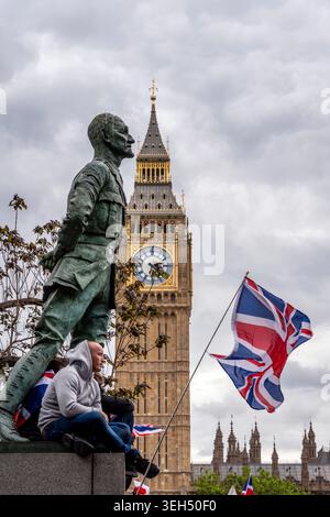 London, UK. 16th May, 2026.  A Man Sits On A Statue In Parliament Square Watching The Tommy Robinson Unite The Kingdom Rally, London, UK. Stock Photo