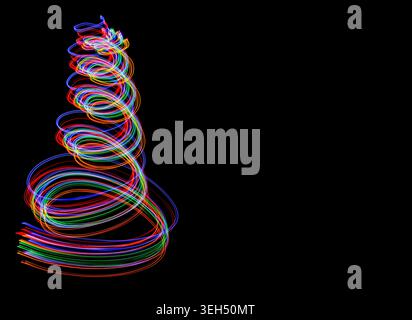 Festive swirling colourful light trails on black background, creating magical seasonal energy with copy space for event advertising. Stock Photo