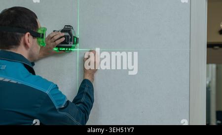 A man measures distance with a laser level.  Stock Photo
