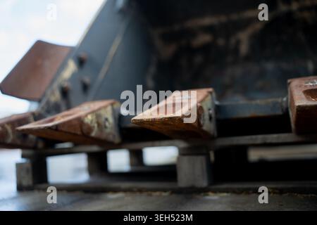 Heavy duty excavator bucket teeth showing heavy rust and wear details on a steel digging attachment used for heavy industrial engineering work Stock Photo