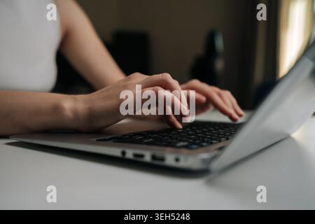 Freelancer hands typing on laptop keyboard, engaging in remote work, online learning, digital communication, showing productivity and efficiency in Stock Photo