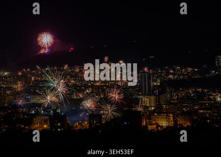 A vibrant burst of colorful fireworks lights up the night sky above Tbilisi, illuminating the city’s skyline and creating a festive atmosphere. Stock Photo
