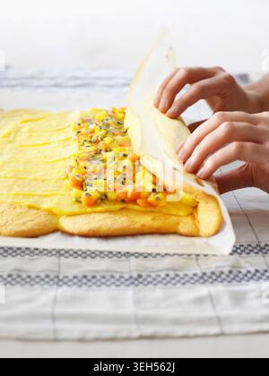 Roll up the sponge cake (film recipe: Christmas stollen with exotic fruit) Stock Photo