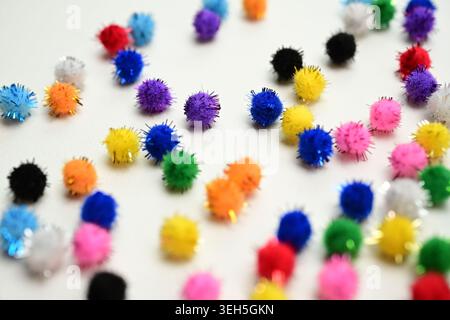 Colorful interlocking hook construction balls scattered on a white surface, creative children's educational building toy pieces in a bright layout. Stock Photo