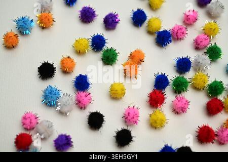 Colorful interlocking hook construction balls scattered on a white surface, creative children's educational building toy pieces in a bright layout. Stock Photo