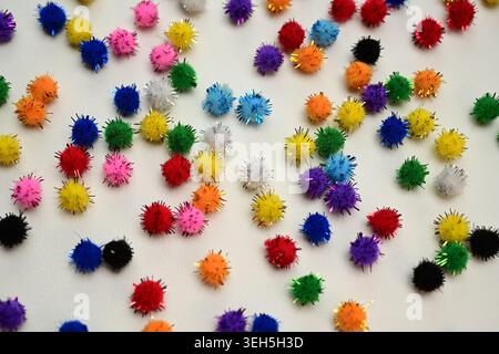 Colorful interlocking hook construction balls scattered on a white surface, creative children's educational building toy pieces in a bright layout. Stock Photo