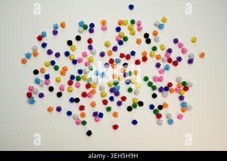 Colorful interlocking hook construction balls scattered on a white surface, creative children's educational building toy pieces in a bright layout. Stock Photo