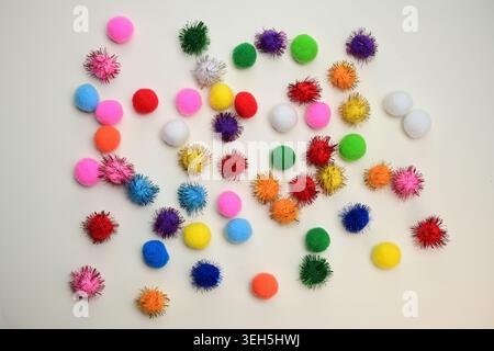 Colorful interlocking hook construction balls scattered on a white surface, creative children's educational building toy pieces in a bright layout. Stock Photo