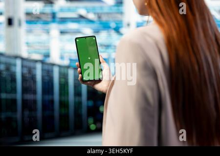 Isolated screen smartphone, protecting against network threats and employee in data center. Auditing systems mockup mobile phone closeup and cybersecurity expert in server farm fixing computer bugs Stock Photo