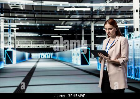 Data center computer scientist using tablet to install and upgrade server racks systems. Server farm employee using automation app on device to monitor IT infrastructure performance Stock Photo