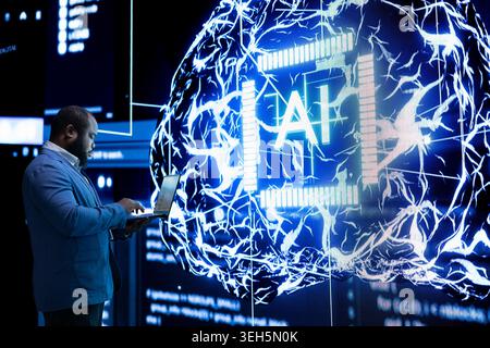 Software developer using advanced AI neural network technology to take decisions. African american man offloading programming tasks to agentic artificial intelligence assistant Stock Photo