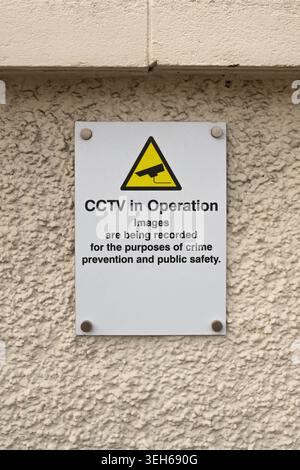 CCTV in operation warning sign mounted on a textured exterior wall, highlighting surveillance, monitoring and public safety concepts Stock Photo