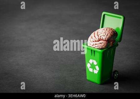Mental Decluttering And Cognitive Renewal Concept. Human Brain In Green Recycling Bin With Recycle Symbol On Dark Concrete Background For Idea Reset A Stock Photo